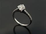 un gros plan d'une bague de fiançailles en diamant posée sur une surface noire