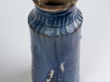 a blue vase that is sitting on a white surface
