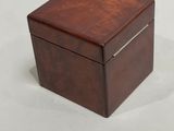 a small wooden box with a lid on a white surface