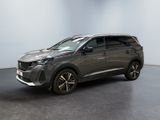 un SUV gris garé dans une pièce au sol noir