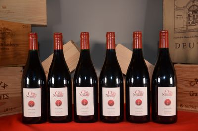 six bottles of red wine are lined up on a table