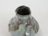 a small vase that is sitting on a white surface