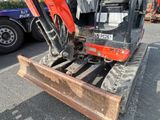 a small excavator that is sitting in the parking lot