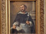 tableau représentant un homme tenant un livre et une fleur, dans un cadre doré