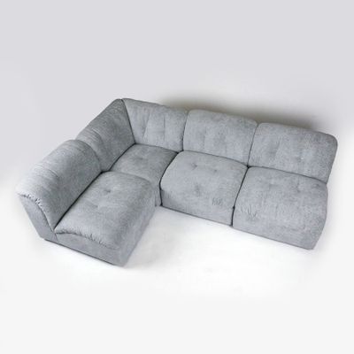 grey sectional sofa with chaise lounger and ottoman on white background