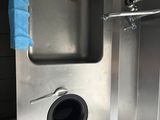 a stainless steel sink with a blue towel hanging from it ' s side