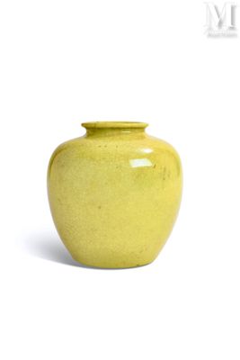 a yellow vase that is sitting on a white surface