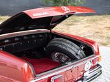 a red car with its trunk open on the street