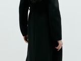 a woman that is standing in a room with a white wall