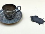 une tasse et une soucoupe posées sur la table, à côté d'un morceau de tissu