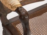 an old fashioned chair with a wooden seat and arm rest