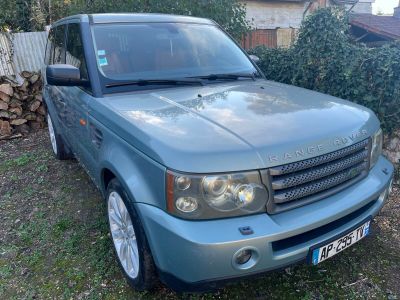 une photo d'un Land Rover bleu garé devant une maison