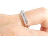 a person ' s hand holding a diamond ring on their finger