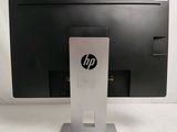 the hp monitor is sitting on a stand on a white surface