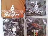 three shirts in plastic bags sitting on top of a table