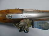 an old gun with a wooden handle on a white surface