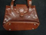 a brown leather purse on a black surface