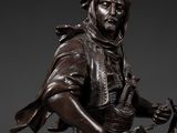bronze statue of a man riding a horse with a hat on his head