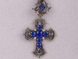 a close up of a necklace with a cross on it