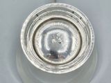 a close up of a silver object on a white surface