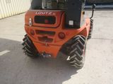 a picture of a small orange tractor parked in a parking lot