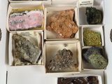 une boîte remplie de cailloux et de pierres, sur lesquels sont apposées des étiquettes