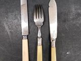 three forks and a knife on a table