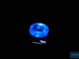 a close up of a blue crystal on a black surface