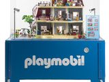une vitrine Playmobil bleue contenant une maison de poupées