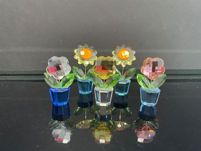 cinq vases remplis de fleurs posés sur une table