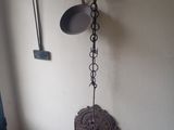 une horloge murale accrochée au mur à côté d'une casserole et d'une poêle