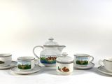 five cups and a teapot sitting on a table
