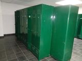 several green lockers are lined up in a row in a public bathroom