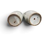 pair of white and brown salt and pepper shakers on a white surface