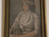 a painting of a woman holding a dog on a wall