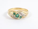 a close up of a gold ring with a green stone and diamonds
