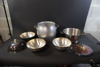 a lot of pots and pans sitting on a table