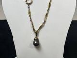 un mannequin blanc portant un collier orné d'une perle noire