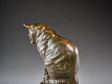 an image of a statue of a cat sitting on a rock