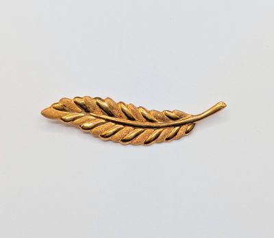 a gold leaf broocht on a white background