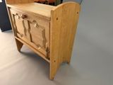 a small wooden cabinet with a door on top of it