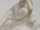 a statue of a woman sitting on top of a bed