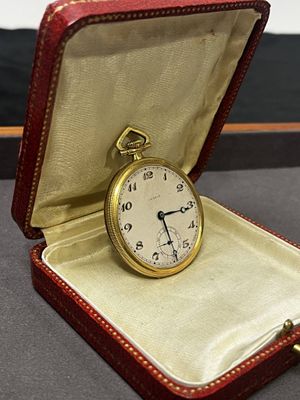 un étui rouge contenant une montre de poche en or