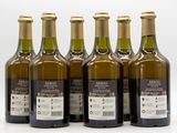 six bottles of olive oil are lined up on a white surface