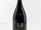 the bottle of red wine is sitting on a white surface