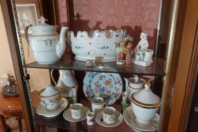 une vitrine en verre sur laquelle sont disposées de nombreuses tasses à thé et à café