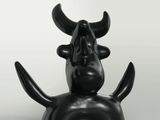 black sculpture of a bull with horns on its head on a white background