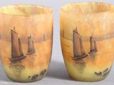 une paire de vases décorés de bateaux, posés sur une table