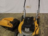 une tondeuse à gazon jaune et noire à côté d'un sac jaune et noir