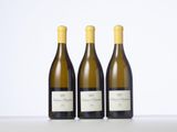 trois bouteilles de vin blanc sont alignées sur une table